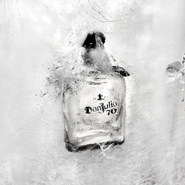 A bottle of Don Julio 70 Cristalino crashing into ice